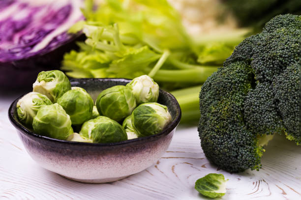 istock Close-up of assorted fresh vegetables on a white wooden table: cabbage, broccoli, cauliflower and Brussels sprouts and red cabbage-organic products 1141371396