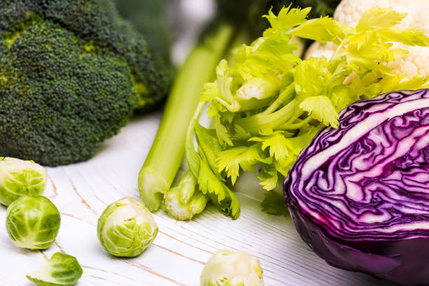 istock Close-up of assorted fresh vegetables on a white wooden table: cabbage, broccoli, cauliflower and Brussels sprouts and red cabbage-organic products 1141371397