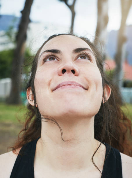 istock Smiling young woman looks up, stretching neck before starting exercise 1141374502