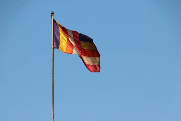 istock Fabric Buddhist flag blown by wind on the flagpole with blue sky background. 1141375733