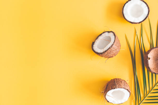 istock Summer composition. Coconut, palm leaves on yellow background. Summer concept. Flat lay, top view, copy space 1141376781