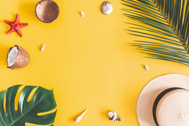 istock Summer composition. Tropical palm leaves, hat, coconut on yellow background. Summer concept. Flat lay, top view, copy space 1141376789