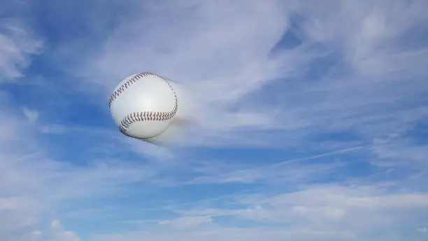 Baseball freeze-frame with speed blur effect on a blue sky background