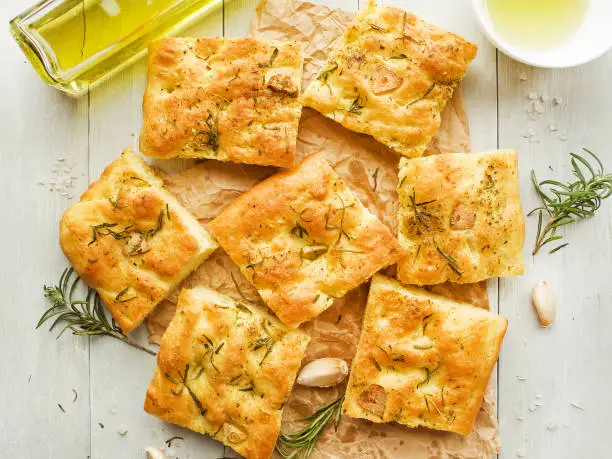 Italian focaccia bread with rosemary, garlic, cherry tomatoes and olive oil. Shallow dof.