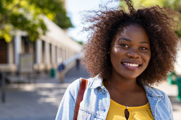 Curvy happy black woman Portrait of young african american woman with curly hair smiling and looking at camera. Black curvy girl in casual clothes enjoying outdoor. Pretty black college student in campus. voluptious stock pictures, royalty-free photos & images