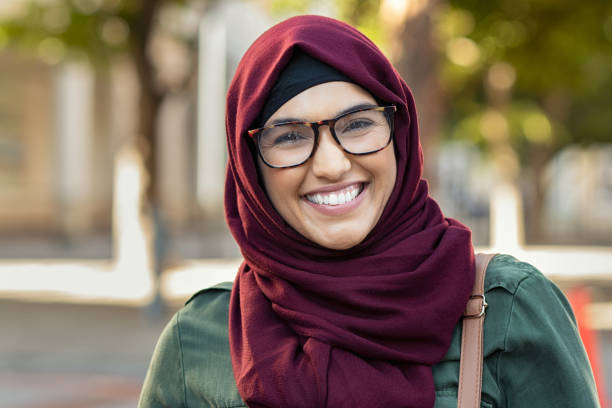 Smiling young woman in hijab Beautiful young muslim woman wearing hijab and spectacles. Islamic curvy woman looking at camera. Closeup face of arabic girl wearing eyeglasses and looking at camera with a big grin. chubby arab stock pictures, royalty-free photos & images