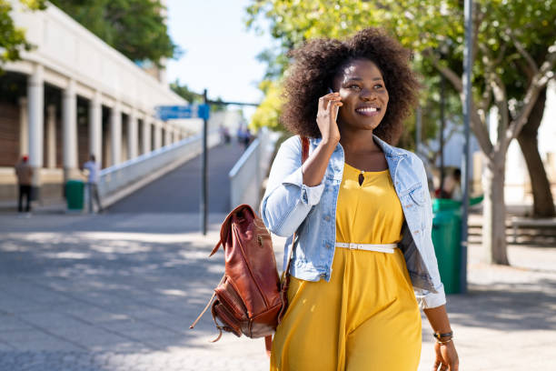 African woman talking on phone Happy young woman in casual walking while talking over phone. Cheerful african american girl with curly hair using smartphone. Black curvy woman talking on phone outdoor. plus size photos stock pictures, royalty-free photos & images