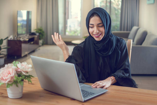 istock Smiling young muslim woman using laptop at home 1141396021