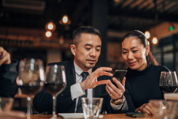 istock Man and woman using smart phone in restaurant 1141396803