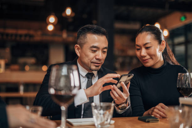 istock Man and lady using smart phone in restaurant 1141396834