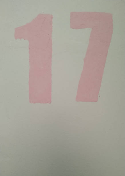 istock Number 17 painted in blue on a pink background. Close-up. 1141396887