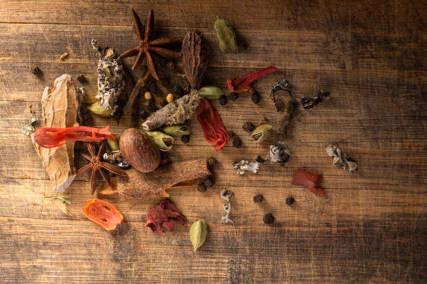 GARAM MASALA DIFFERENT TYPES OF GARAM MASALA ON A WOODEN BACKGROUND WITH DRAMATIC STUDIO LIGHTING ayurveda cardamom star anise spice stock pictures, royalty-free photos & images