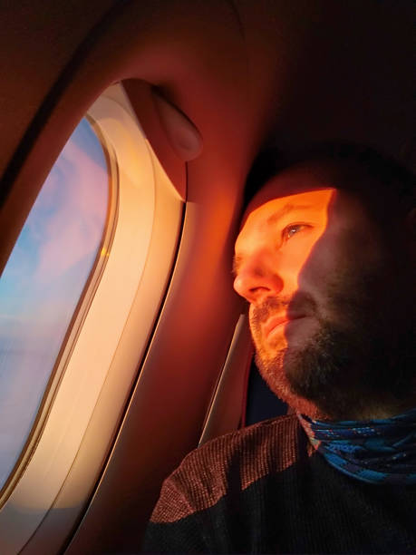 istock Man looking out the porthole in the airplane 1141398183