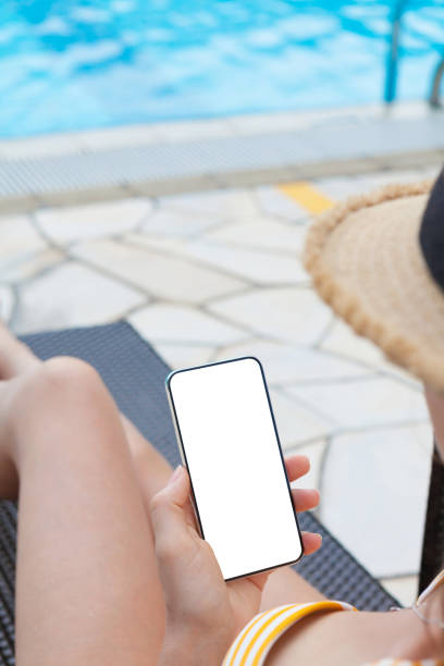 istock Young woman using smartphone near a swimming pool 1141398641