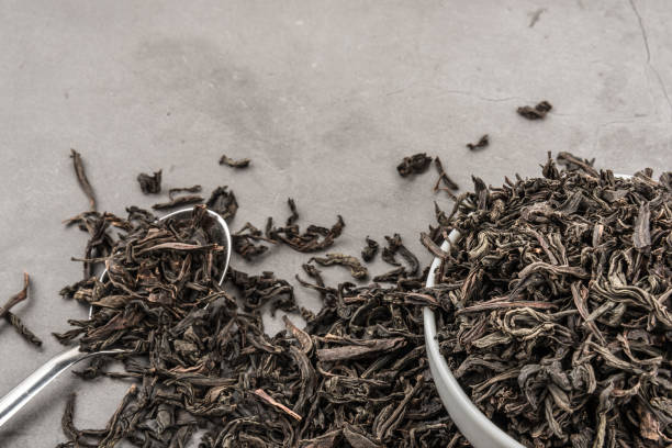 istock Dried tea in a white ceramic cup with a spoon on a gray textured background. 1141399695
