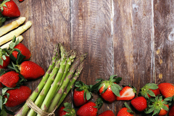istock White and green asparagus with strawberries on wood 1141401170