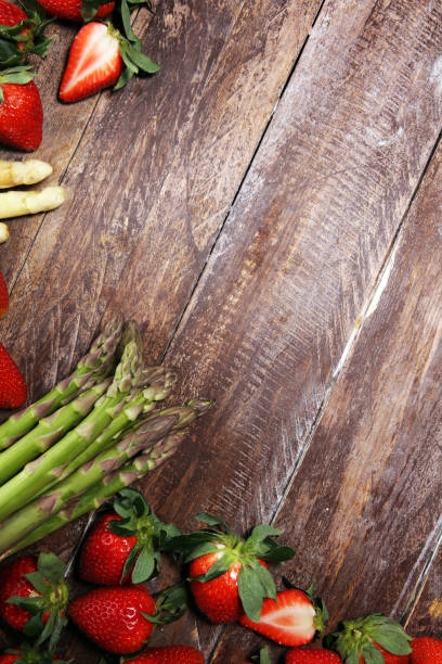 istock White and green asparagus with strawberries on wood 1141403405