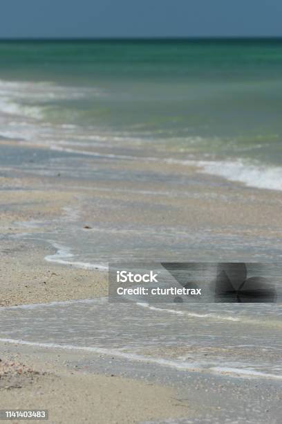 Turquoise Sea With Small Waves And Spreading Surf On Lightcolored Sand Stock Photo - Download Image Now