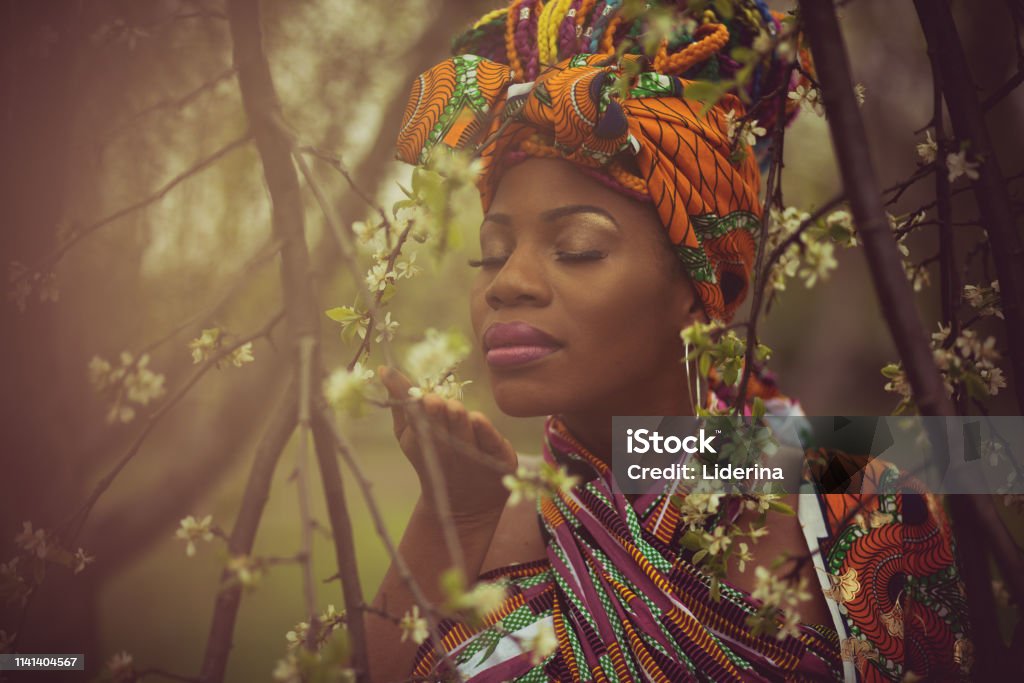 Wonderful scents of spring. Wonderful scents of spring. African American woman in the park. Flower Stock Photo