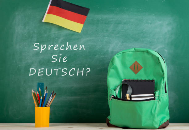 緑のバックパック、黒板に「sprechen」、ドイツの国旗、学校用品、手帳 - text talking translation learning ストックフォトと画像