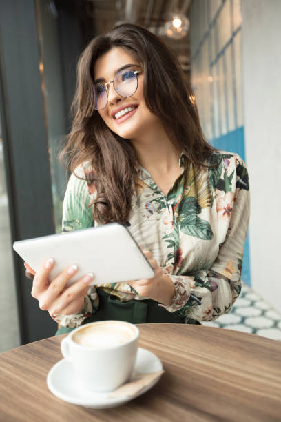 istock Beautiful woman using ebook reader in a cafe. 1141404807