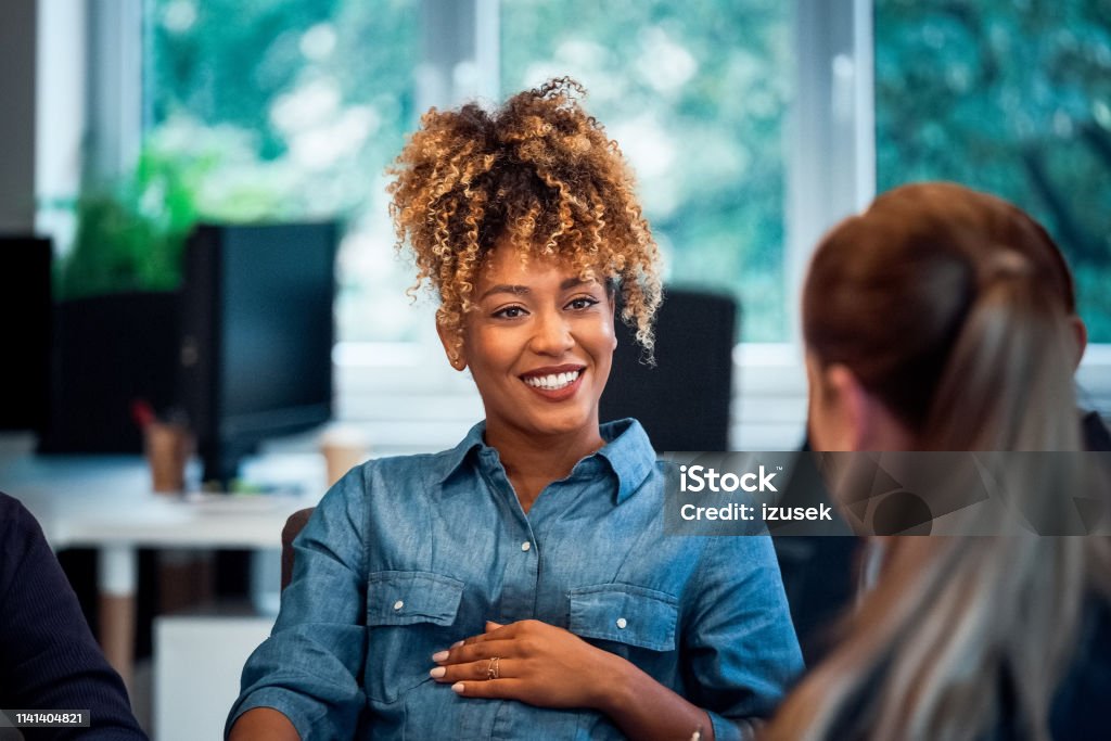 Smiling pregnant woman working in new office Confident smiling businesswoman looking at colleague. Pregnant expertise is working in new office. Business professionals are discussing. Pregnant Stock Photo