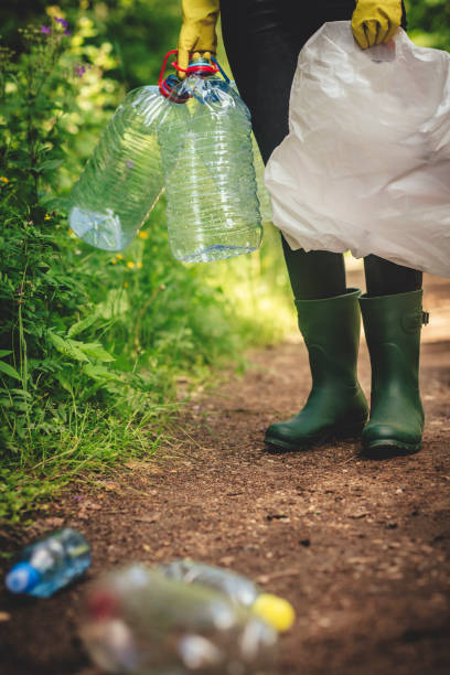 istock Volunteer collects plastic bottles outdoors 1141406882