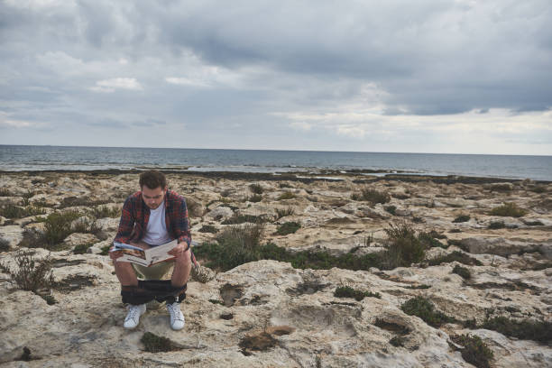 istock Dreamful guy sitting on lavatory with journal outdoor 1141408556
