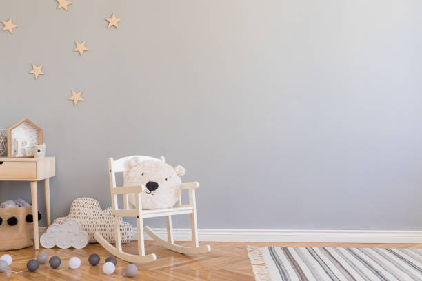 おもちゃ、子供の椅子、テディベアと小さな棚と自然のバスケットとスタイリッシュなスカンジナビア新生児の赤ちゃんの部屋。灰色の背景壁、木製の寄木細工と星のパターンと近代的なイ� - ベビールーム ストックフォトと画像