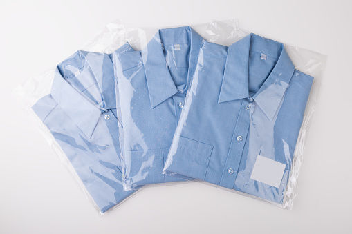 new monochrome blue shirts wrapped in foil, white background
