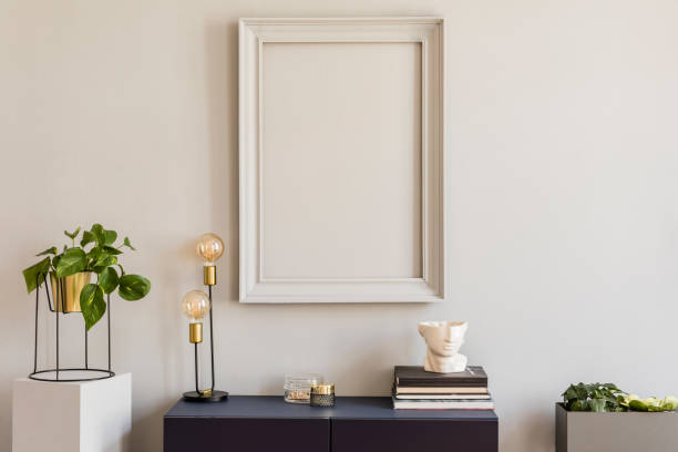 istock Scandi and design home decor with mock up grey poster frame, navy blue shelf with stylish accessories, lamp and books. Stylish and minimalistic room interior with big plants in gold pot. 1141409647