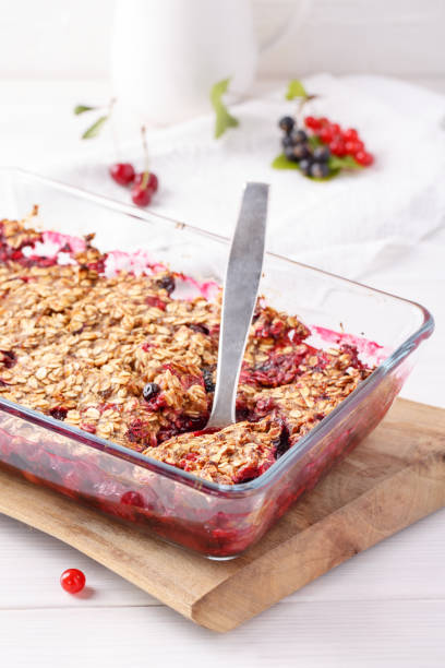 istock Apple and berry crumble, topped with oats in glass baking dish on white table. Crispy fruit pie, healthy summer dessert. Close-up. 1141410991
