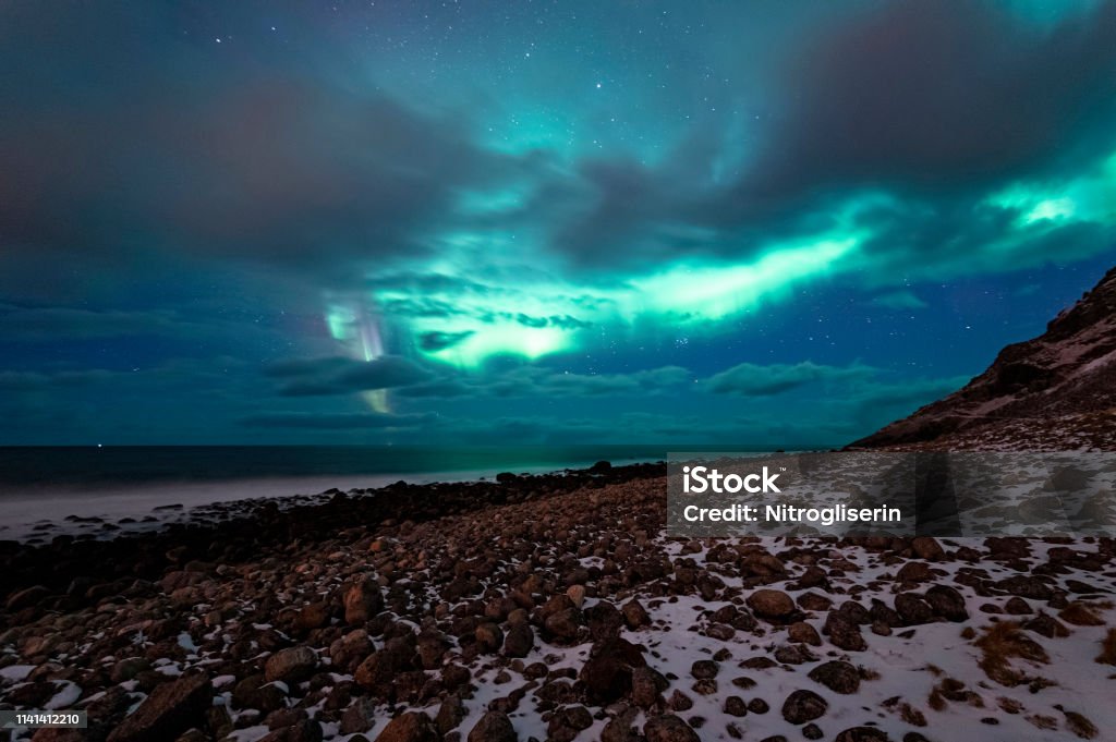 Northern Lights in Unstad Northern lights spotted in Unstad, Lofted in a cloudy sky. Lofoten Stock Photo