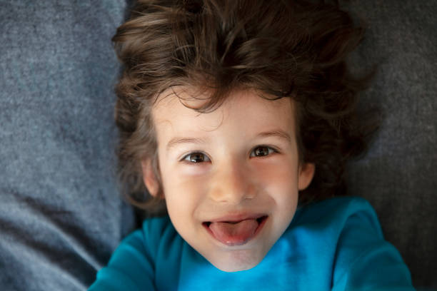Beautiful, happy boy, smiling and enjoying indoors. High angle view.