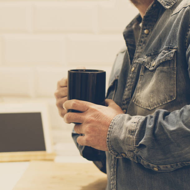 istock Man with a cup of coffe in his hand 1141415174
