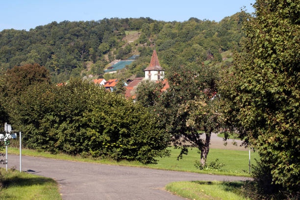 istock Walking path passing rural village with apple orchard 1141415285