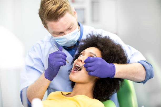 istock Dentist using an excavator sickle probe and a mouth mirror to perform a dental check up 1141415336