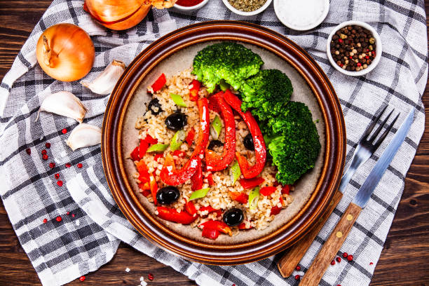 istock Groats and vegetables on wooden table 1141415830