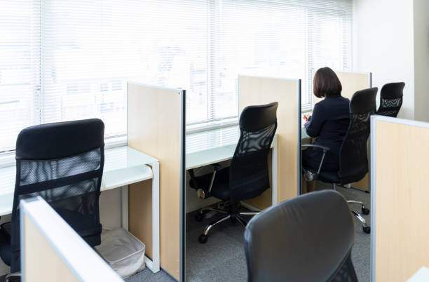 woman sitting at desk and working - hot desking imagens e fotografias de stock