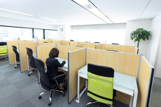 woman sitting at desk and working - hot desking imagens e fotografias de stock