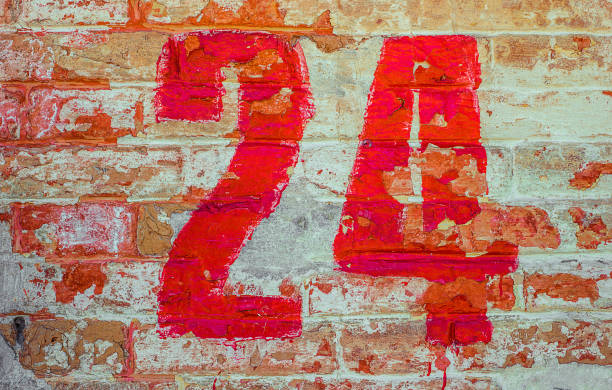 istock Number Twenty Four A Drawn By Red paint On Whitewashed Brick Wall. Shabby Building With Damaged cracked Plaster 1141417488