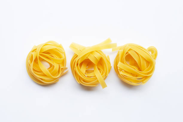 istock Uncooked Italian pasta tagliatelle nest on white background 1141417868