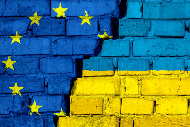 Flags of European union EU and Ukraine on the brick wall with big crack in the middle. stock photo