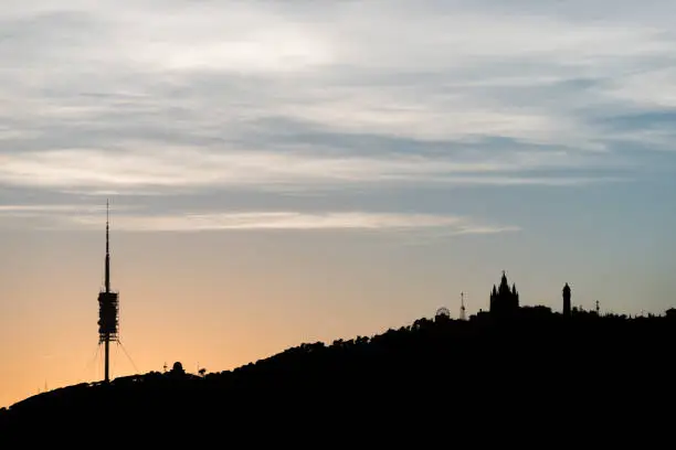 Silhouette of Tibidabo hill at the sunset in Barcelona city. Spain.