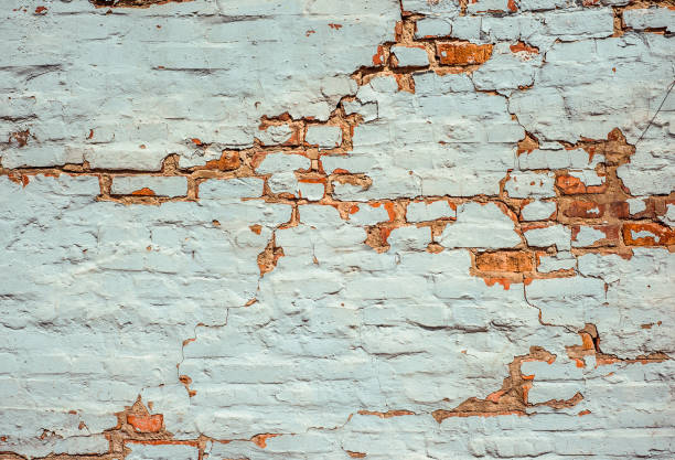 istock Empty Old Brick Wall White Painted Texture. Shabby Building With Damaged crack Plaster 1141419283