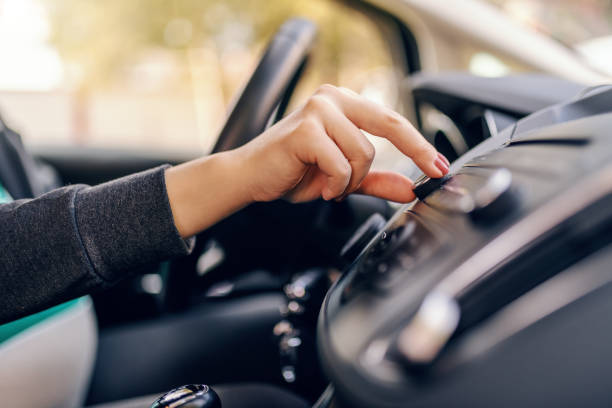 close up of pregnant woman searching radio station while sitting in car. other hand on steering wheel. - land vehicle audio imagens e fotografias de stock