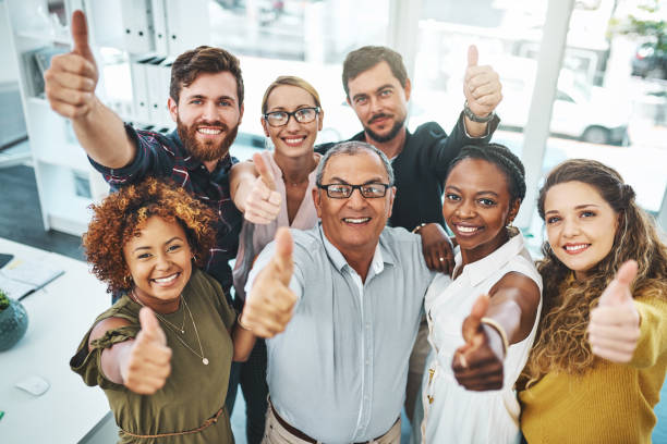 Your hard work hasn't gone unnoticed Portrait of a group of businesspeople showing thumbs up in an office thumbs up photos stock pictures, royalty-free photos & images