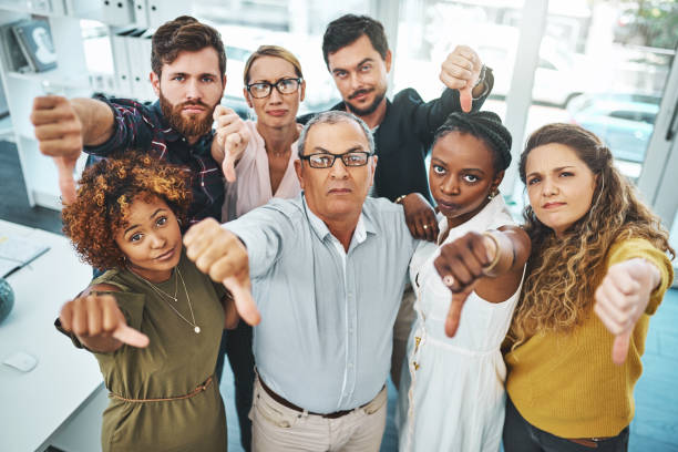 Better luck next time Portrait of a group of businesspeople showing thumbs down in an office happy and sad worker stock pictures, royalty-free photos & images