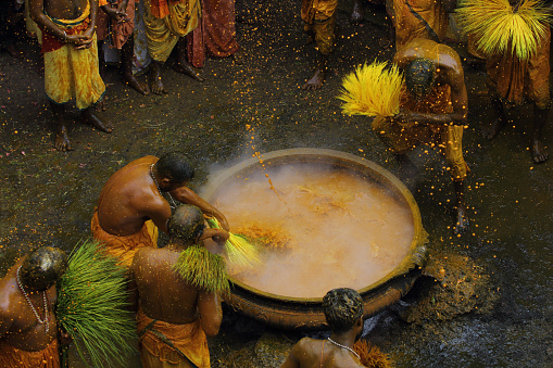 Chengannur, India - April 09, 2019 : Unidentified male devotees perform holy bath ritual with hot turmeric water during the annual festival held at Amman temple in Chengannur, Kerala, India