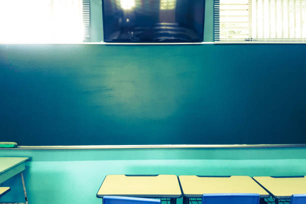 School classroom in blur background without young student; Blurry view of elementary class room no kid or teacher with chairs and tables in campus.